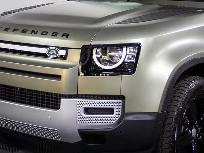 The front of a green Land Rover Defender finished in satin
