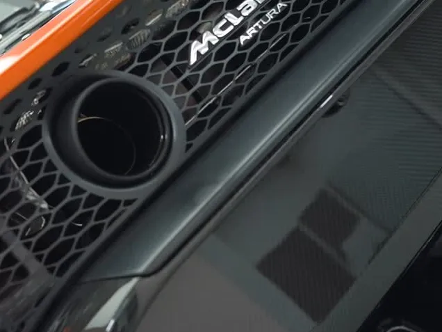A close view of the front intake and Artura badge on an orange McLaren