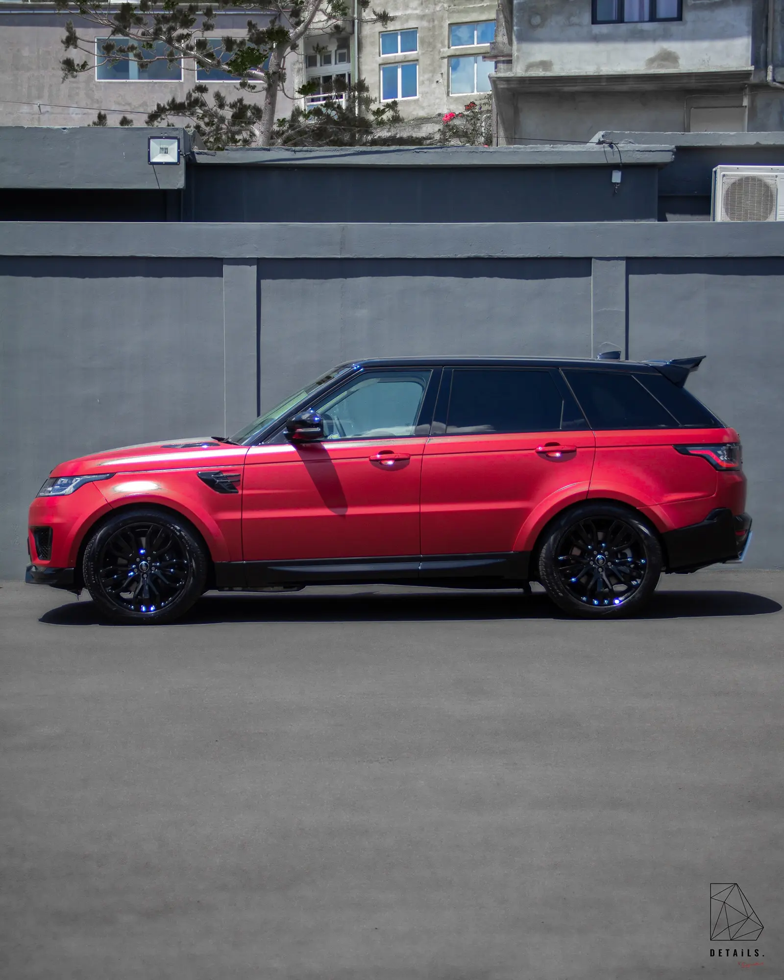 A red Range Rover Sport with a STARTECH body kit, seen in profile