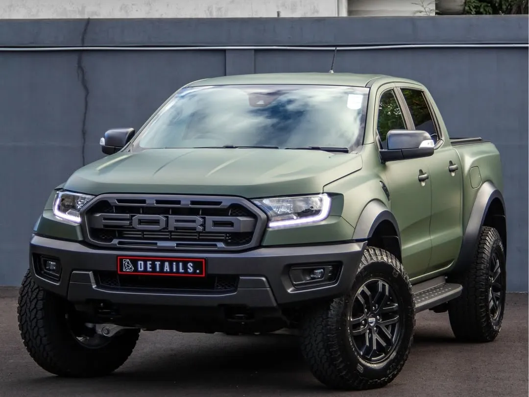 A Ford Ranger Raptor wrapped in matte military green, photographed front three-quarter